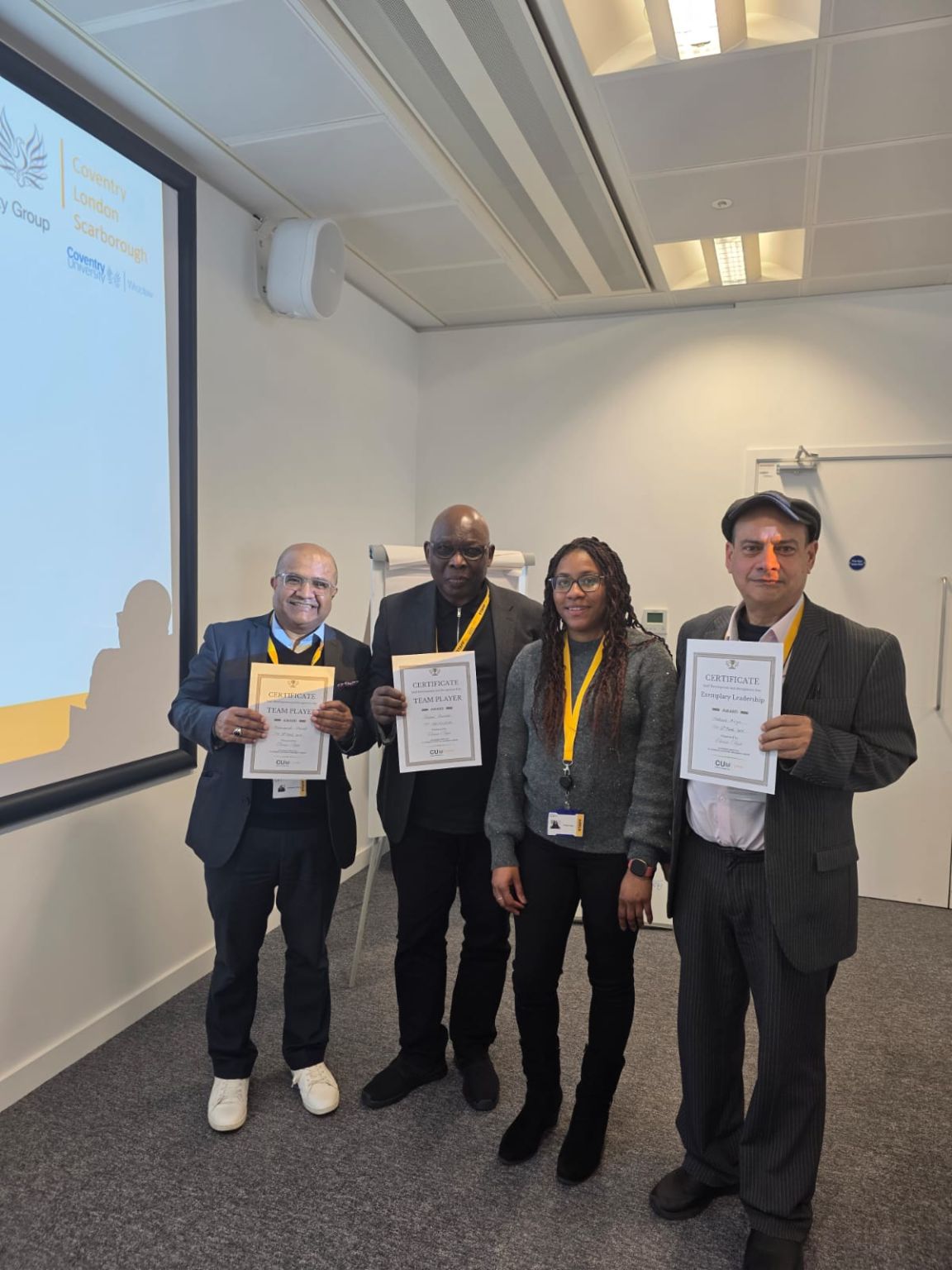 Dr Mohammad Masud with colleagues, each holding certificates at an academic awards event