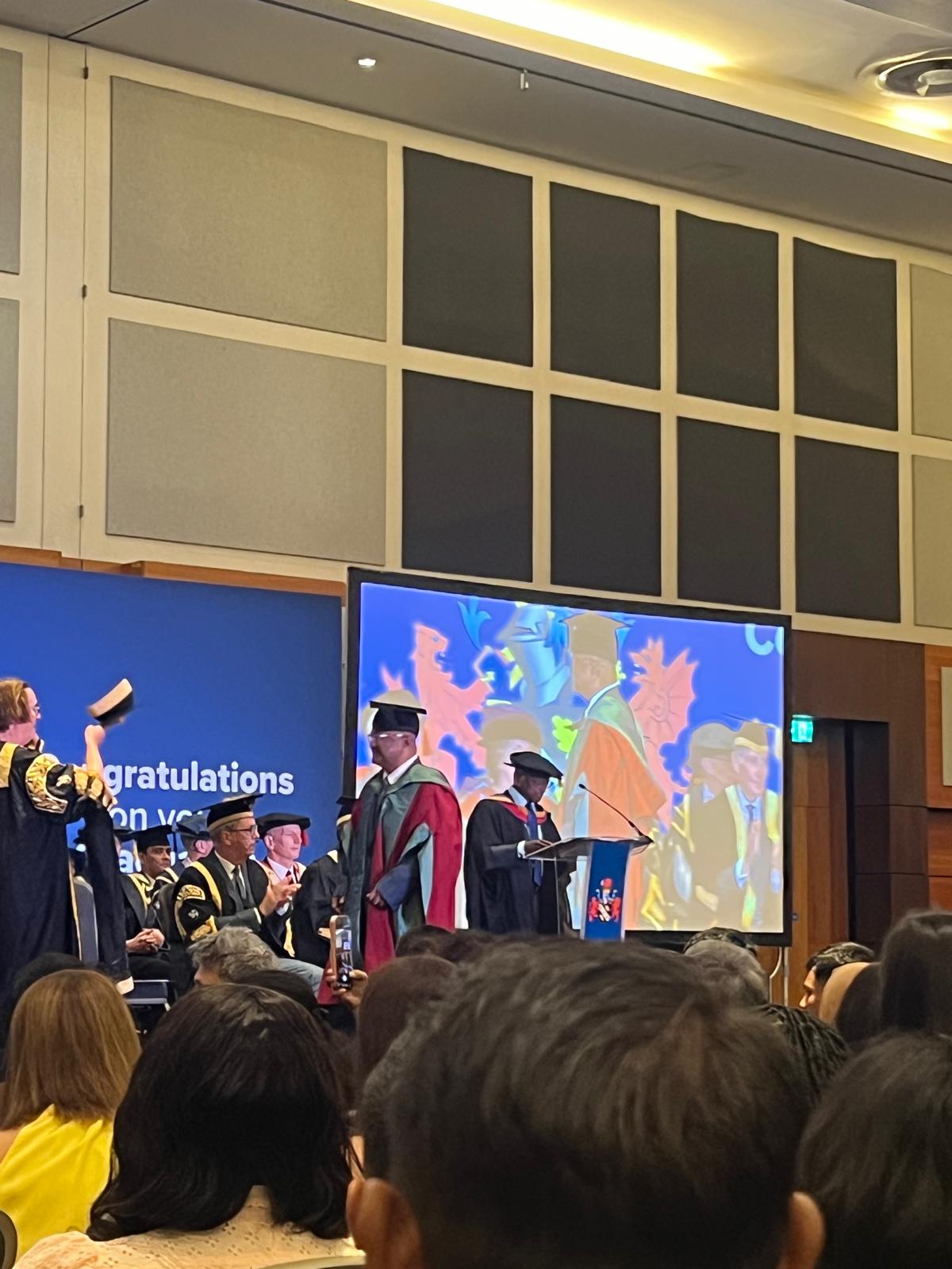 Dr Mohammad Masud on stage in academic dress during the graduation ceremony